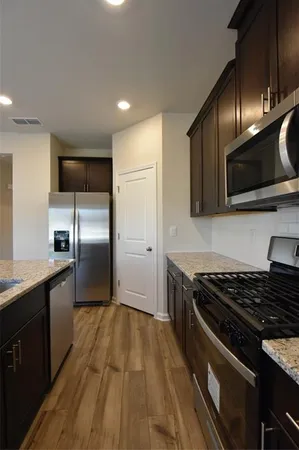 a kitchen with granite countertop stainless steel appliances and wooden cabinets