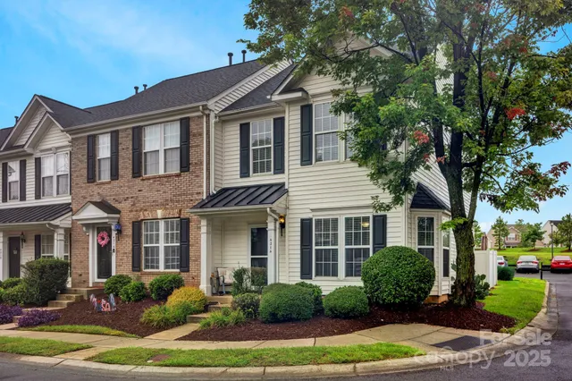 a front view of a house with a yard and potted plants