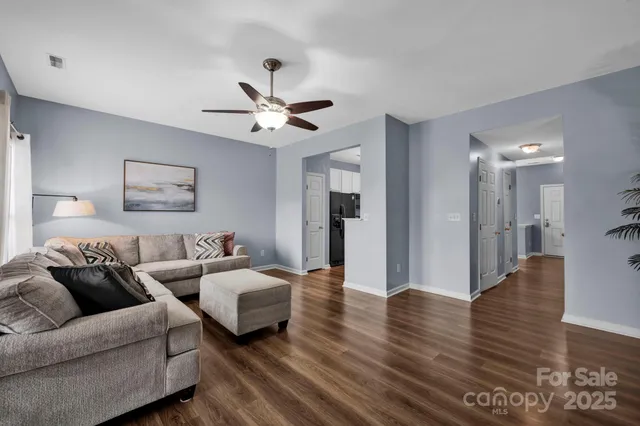 a living room with furniture and a wooden floor