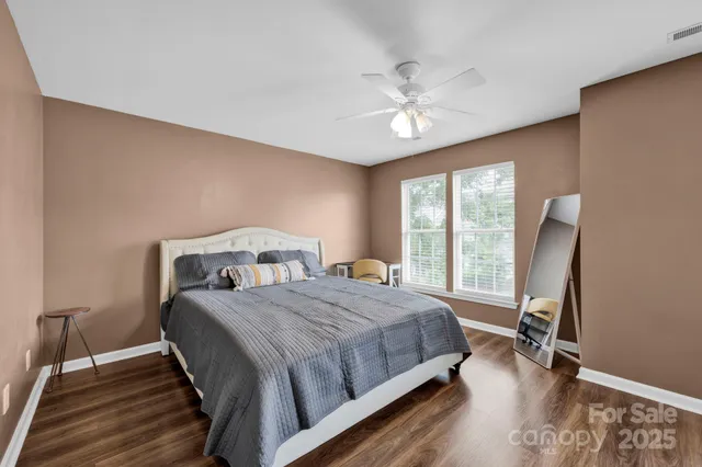 a bedroom with a bed a chandelier and a window