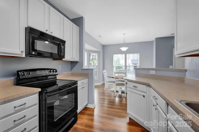 a kitchen with stainless steel appliances a stove microwave and sink
