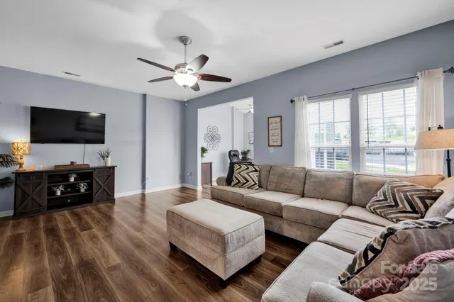 a living room with furniture and a flat screen tv with wooden floor