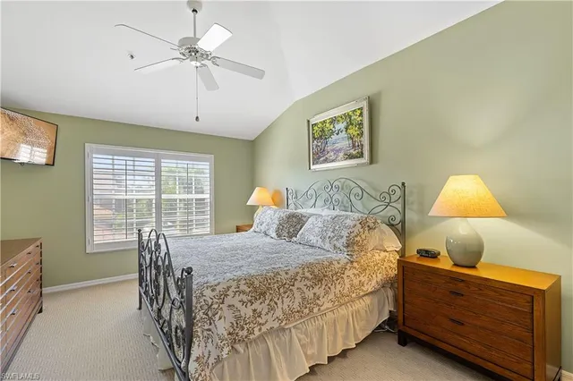 a bedroom with a bed and a table in it with window