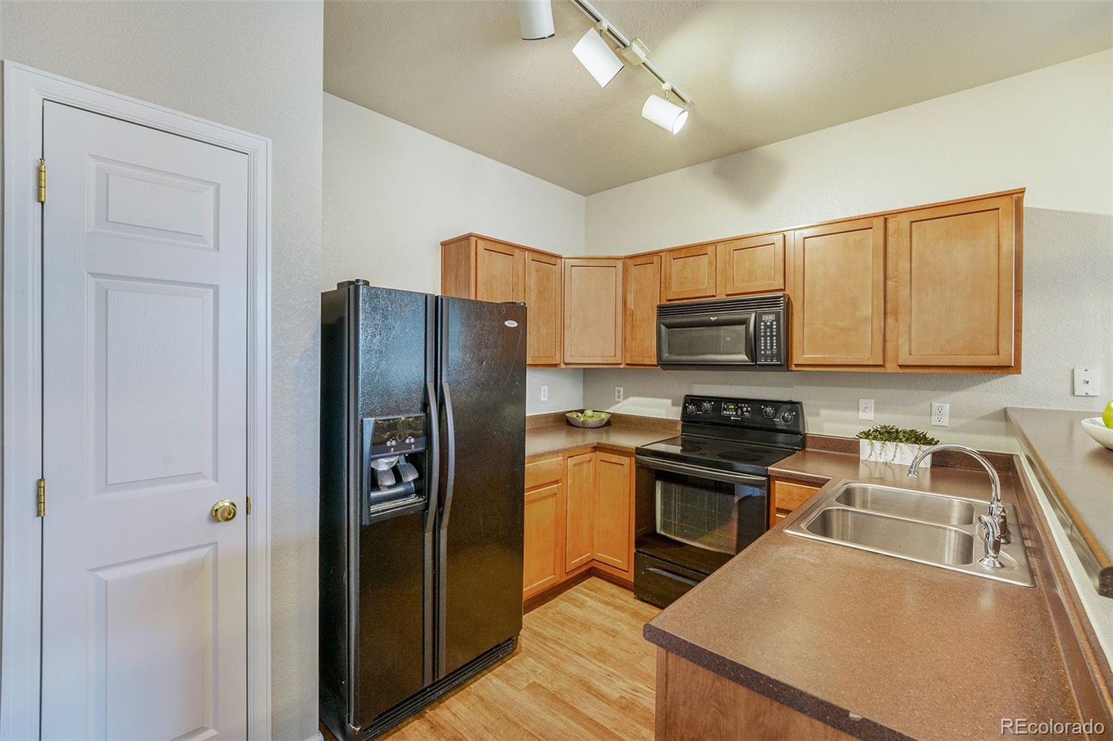 4623 Flower Street Wheat Ridge, CO 80033 - Photo 6 of 23 a kitchen with stainless steel appliances granite countertop a refrigerator a stove top oven a sink and dishwasher