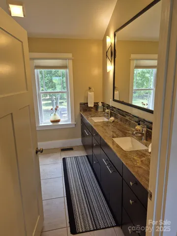 a bathroom with a granite countertop sink and a mirror