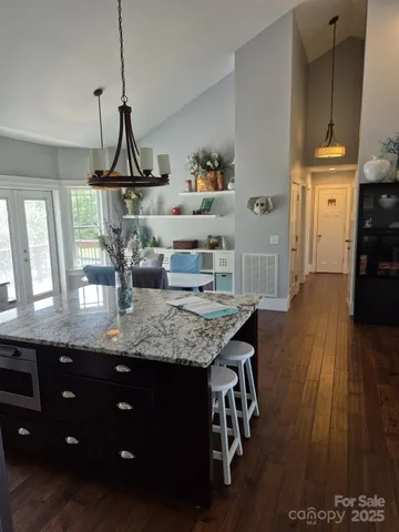 a kitchen with stainless steel appliances granite countertop a sink dishwasher and wooden floor