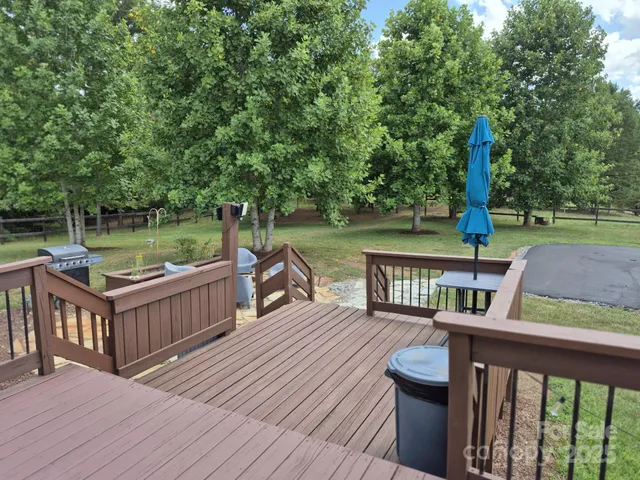a balcony with wooden floor table and chairs