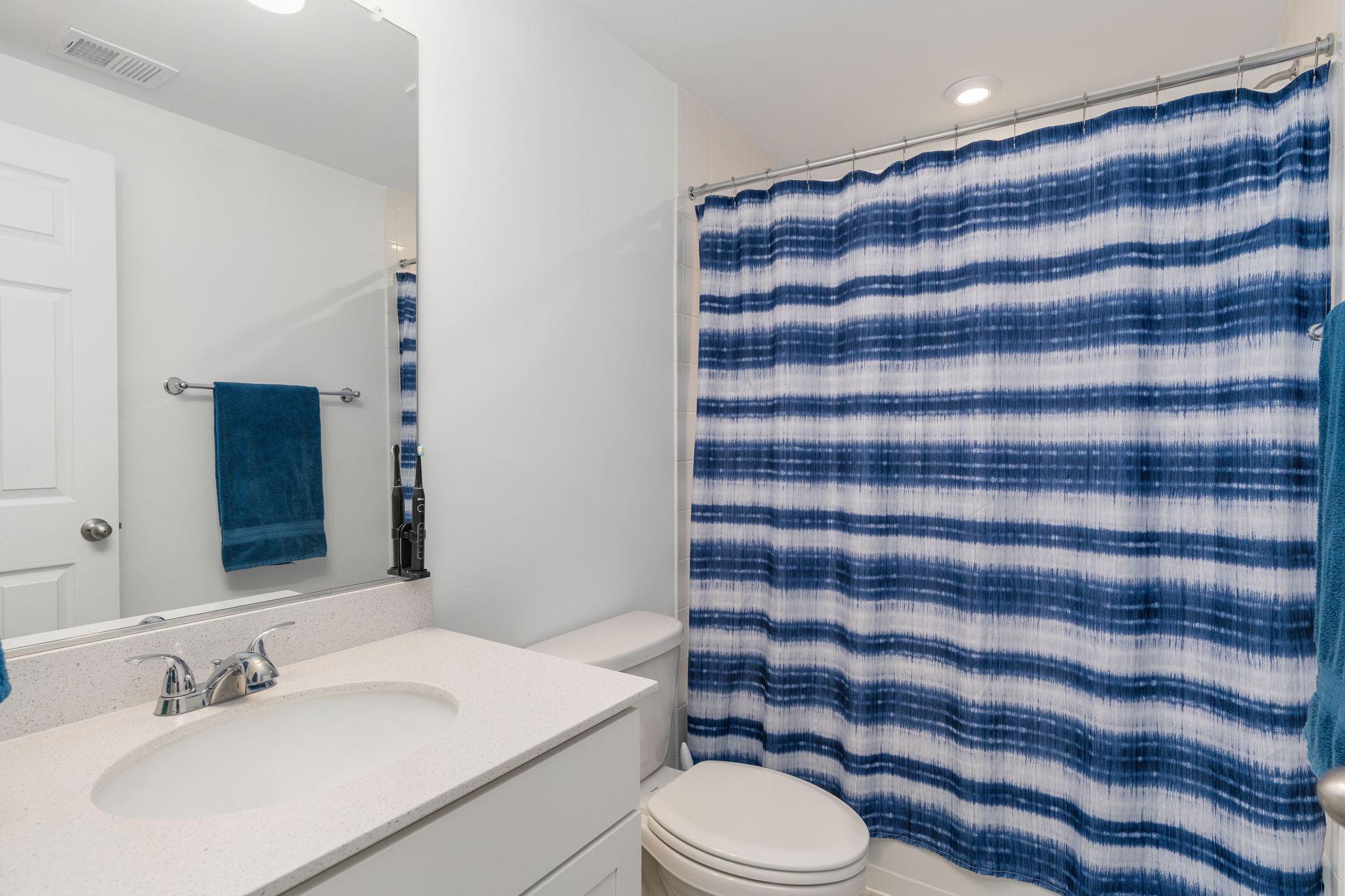 6371 Pointer Lane King George, VA 22485 - Photo 32 of 38 a bathroom with a sink a toilet a mirror and shower curtain