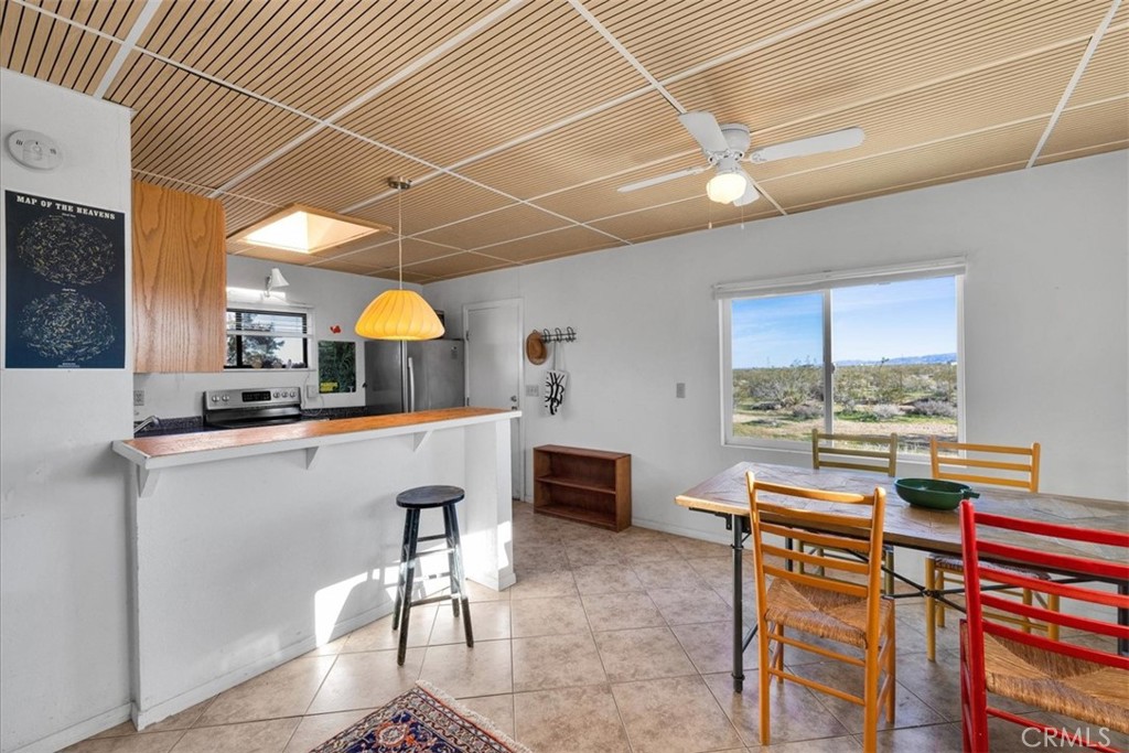 437 Mallow Road Landers, CA 92285 - Photo 17 of 52 a kitchen with stainless steel appliances kitchen island granite countertop a table chairs in it and wooden floors