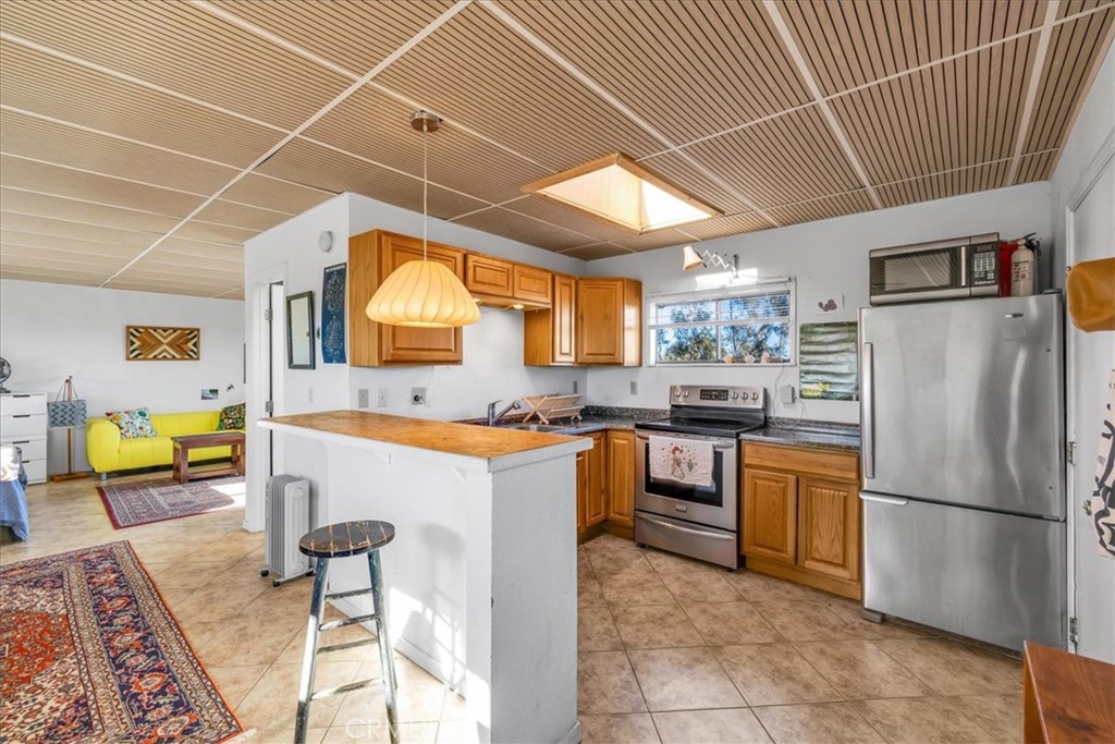 437 Mallow Road Landers, CA 92285 - Photo 19 of 52 a kitchen with stainless steel appliances granite countertop a sink a stove a refrigerator a washer and dryer