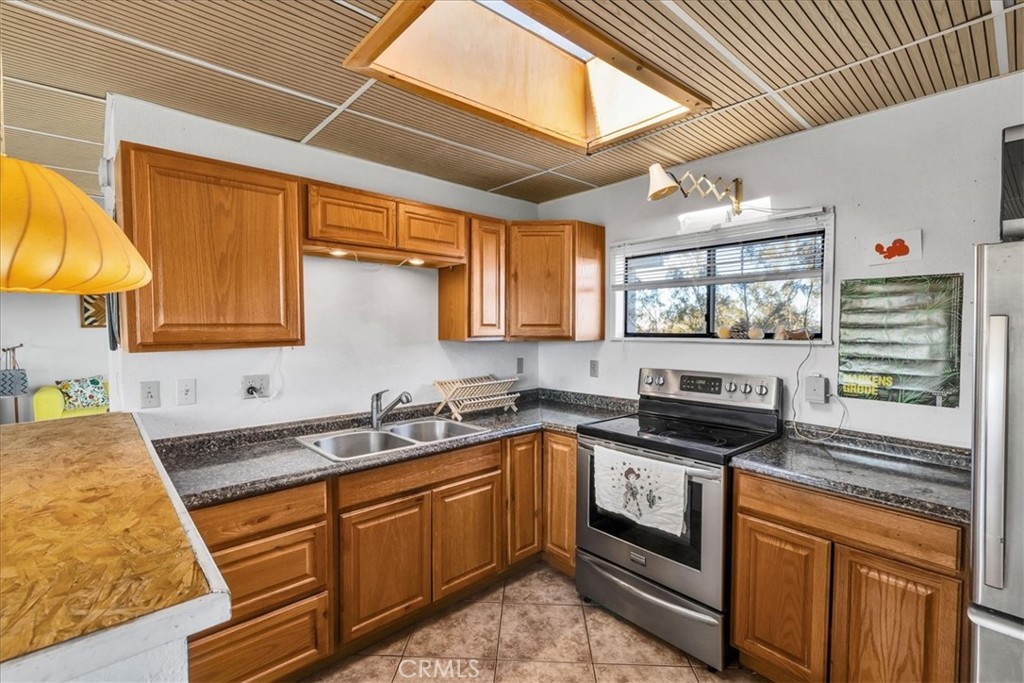 437 Mallow Road Landers, CA 92285 - Photo 22 of 52 a kitchen with stainless steel appliances granite countertop a stove sink and cabinets