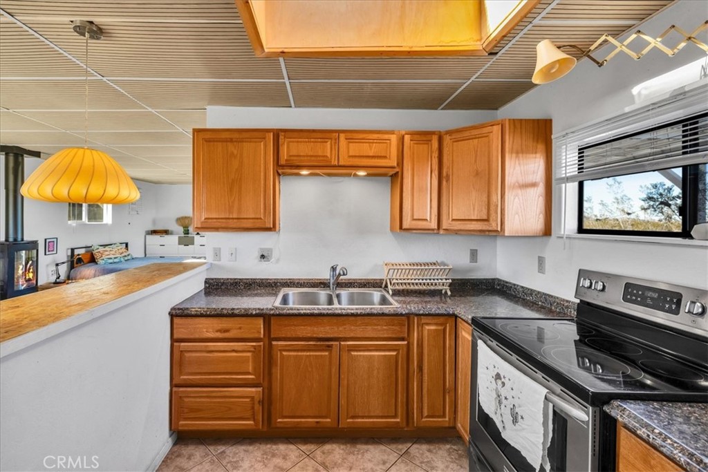 437 Mallow Road Landers, CA 92285 - Photo 23 of 52 a kitchen with stainless steel appliances granite countertop a sink a stove and cabinets