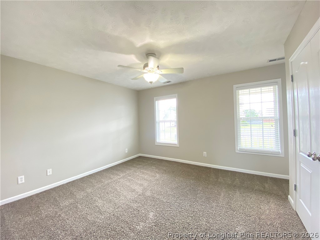 58 Polk Street Spring Lake, NC 28390 - Photo 22 of 26 an empty room with chandelier fan and windows