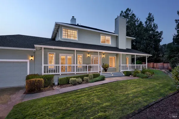 a view of a house with a yard and sitting area