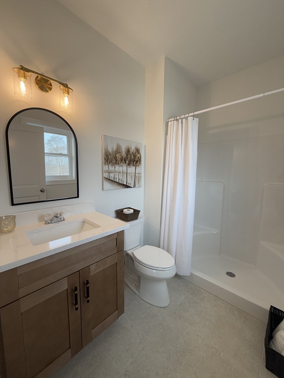 70 Oswego Street Bellingham, MA 02019 - Photo 11 of 28 a bathroom with a toilet sink and mirror