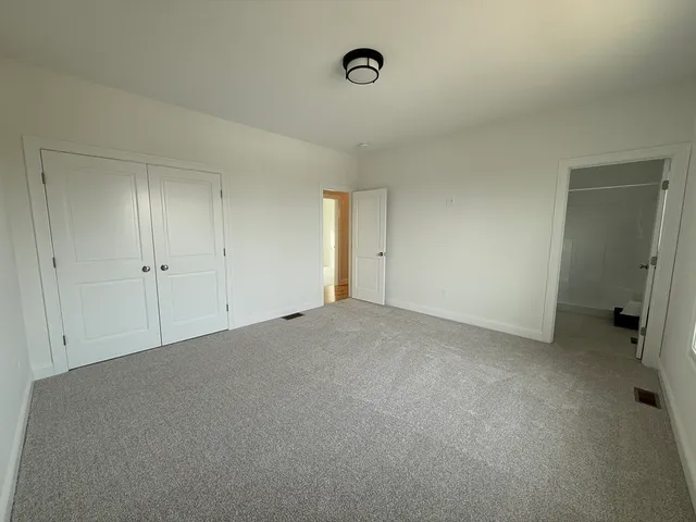 a large kitchen with stainless steel appliances granite countertop a sink a microwave oven a stove and white cabinets with wooden floor