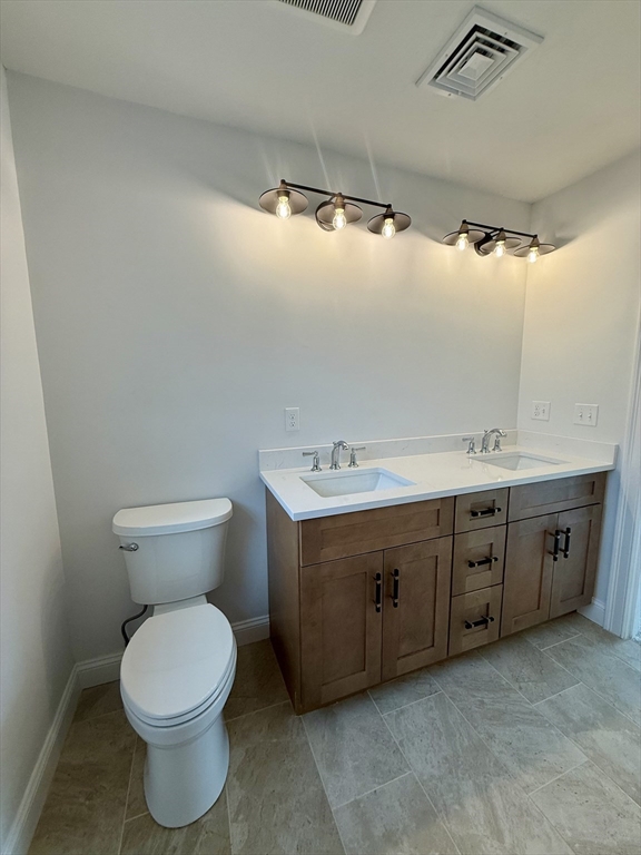 70 Oswego Street Bellingham, MA 02019 - Photo 15 of 28 a spacious bathroom with a double vanity sink and a toilet
