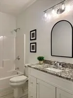 a kitchen with kitchen island granite countertop wooden floor and a chandelier