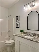 a kitchen with kitchen island granite countertop wooden floor and a chandelier