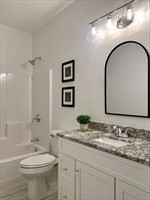 70 Oswego Street Bellingham, MA 02019 - Photo 23 of 28 a bathroom with a granite countertop toilet sink and mirror