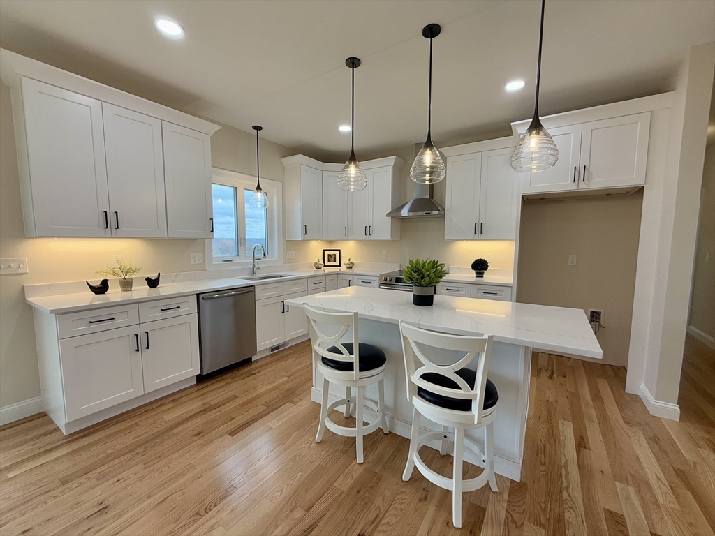 70 Oswego Street Bellingham, MA 02019 - Photo 5 of 28 a kitchen with kitchen island white cabinets and white appliances