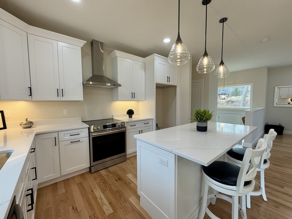 70 Oswego Street Bellingham, MA 02019 - Photo 6 of 28 a kitchen with granite countertop a stove a sink a dining table and chairs