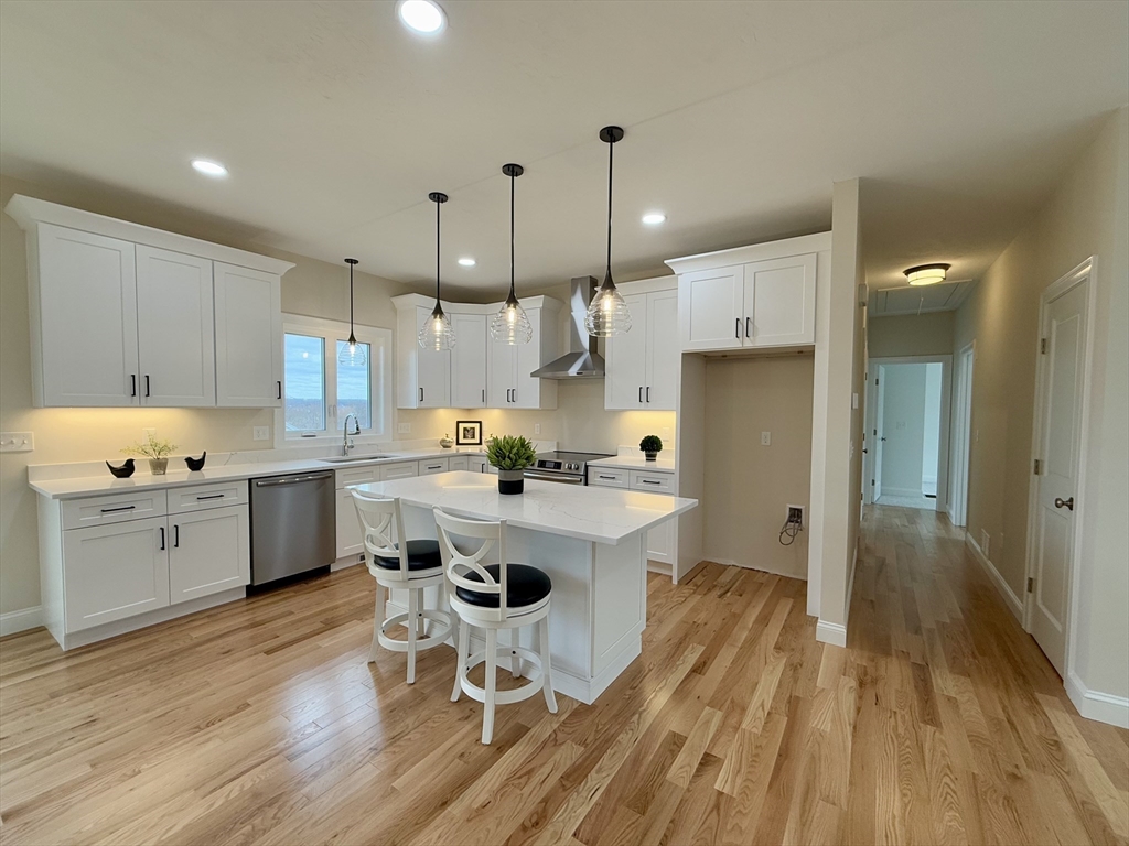 70 Oswego Street Bellingham, MA 02019 - Photo 9 of 28 a kitchen with a sink a refrigerator and wooden floor