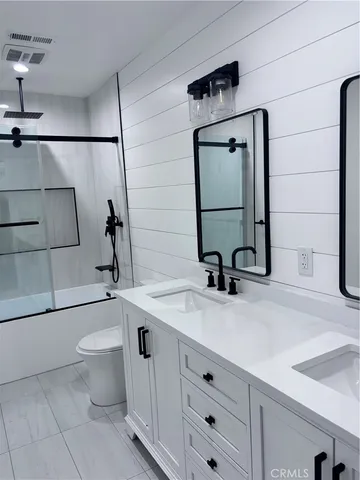 a bathroom with a sink a toilet and mirror