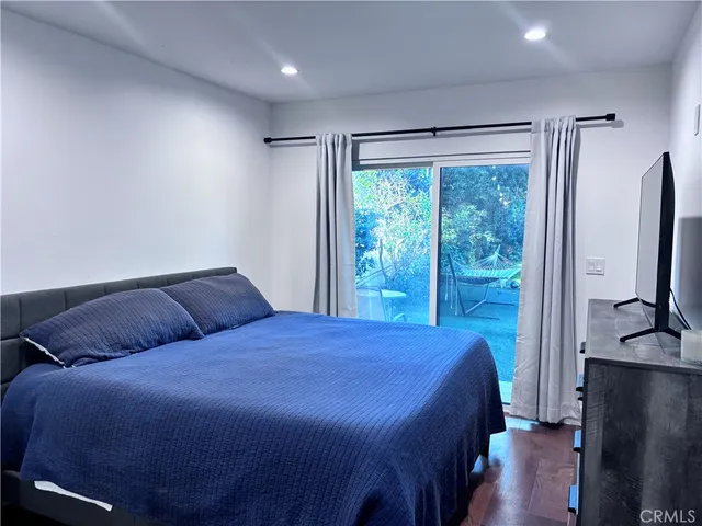 a bedroom with a large bed and a flat tv screen