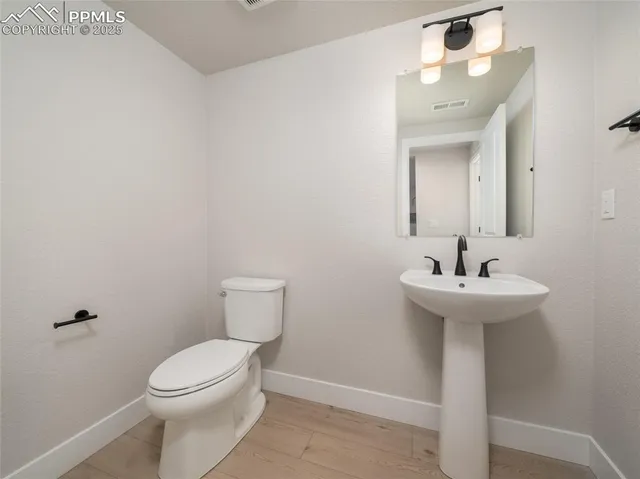 a bathroom with a sink a toilet and mirror
