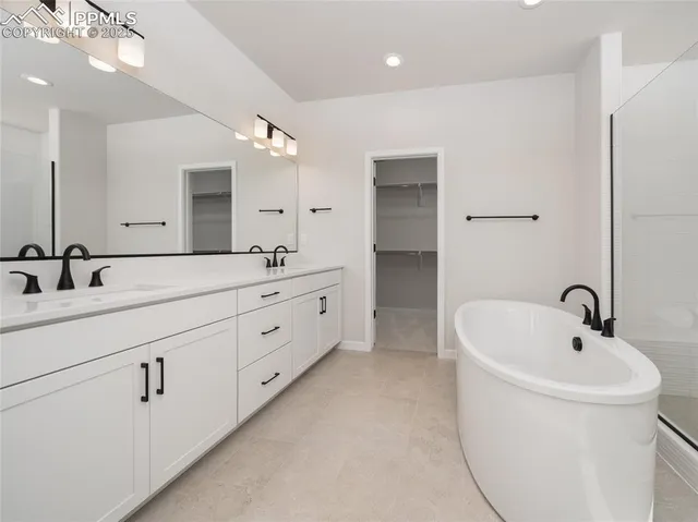 a bathroom with a double vanity sink mirror and bathtub