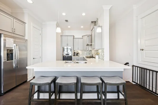 a dining room with stainless steel appliances a table chairs and kitchen view
