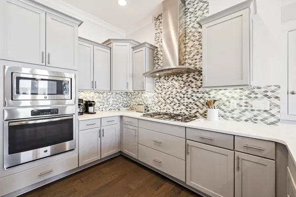 a kitchen with granite countertop white cabinets stainless steel appliances and a counter space