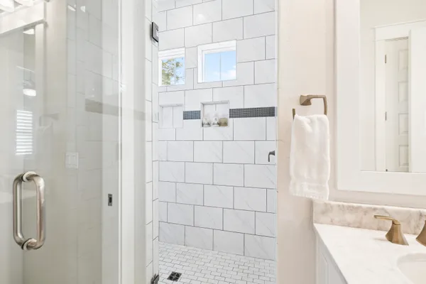 a bedroom with a large bed and a chandelier fan