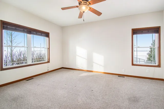 an empty room with a window and a ceiling fan
