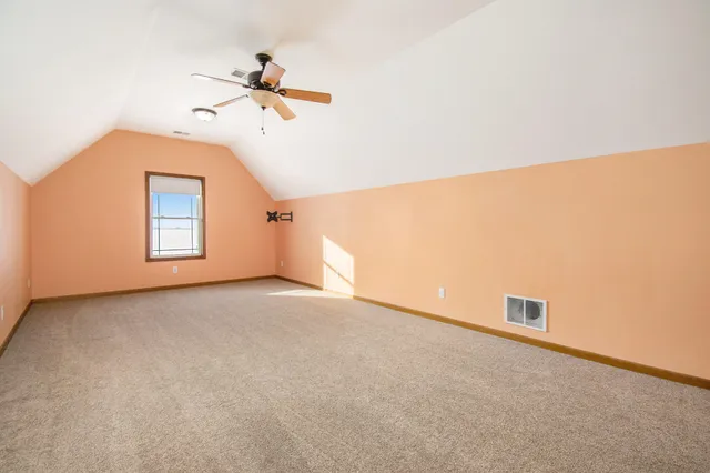 a view of a big room with a ceiling fan and a window