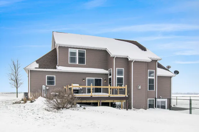 a front view of a house with a yard covered in snow