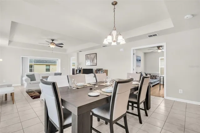 a view of a dining room with furniture a chandelier and wooden floor