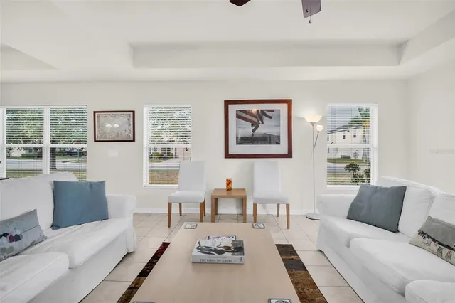a living room with furniture a rug kitchen view and a table
