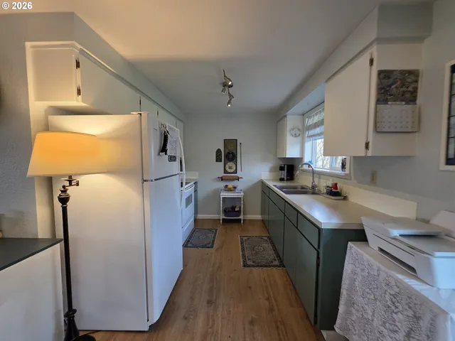 a kitchen with kitchen island stainless steel appliances a sink stove refrigerator and cabinets