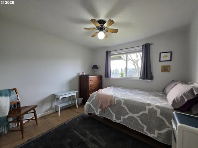 a bedroom with a bed and a chandelier next to a window