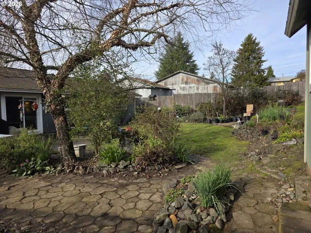 a view of a house with garden and trees in the background