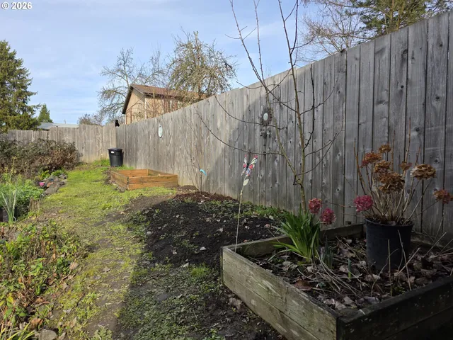 a view of a house with a garden and trees