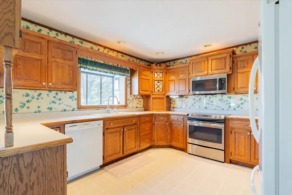 an empty room with chandelier fan and windows