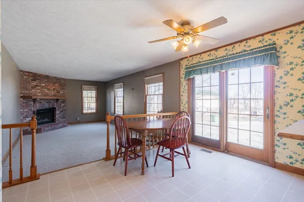 a view of an empty room with window and chandelier fan