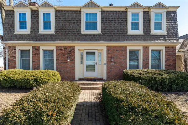 a front view of a brick house with a yard