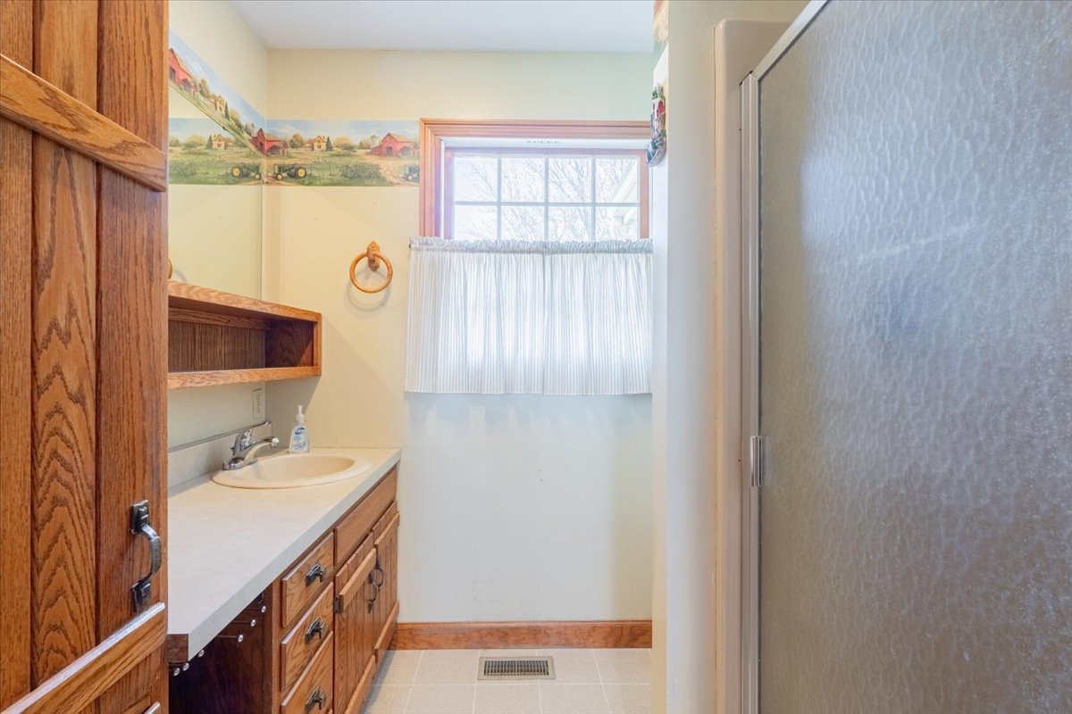 21389 North 2875 East Road Lexington, IL 61753 - Photo 23 of 44 a bathroom with a sink a mirror and a window