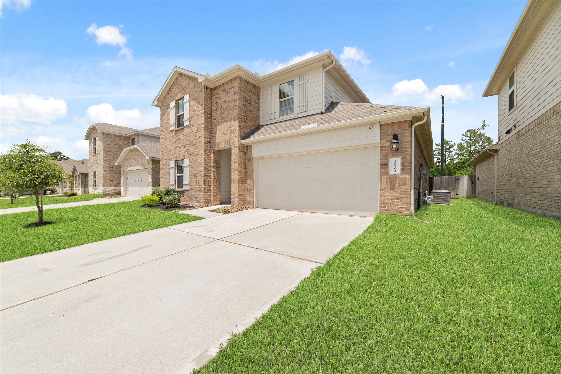 23702 Harrow Field Ln Spring Spring, TX 77373 - Photo 2 of 32 a front view of a house with a yard and garage