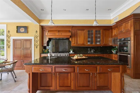 a kitchen with stainless steel appliances granite countertop a sink a stove and a wooden cabinets