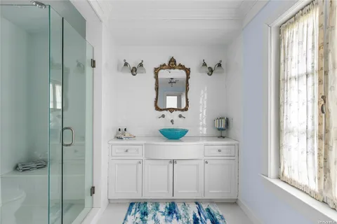 a bathroom with a sink a mirror and a window